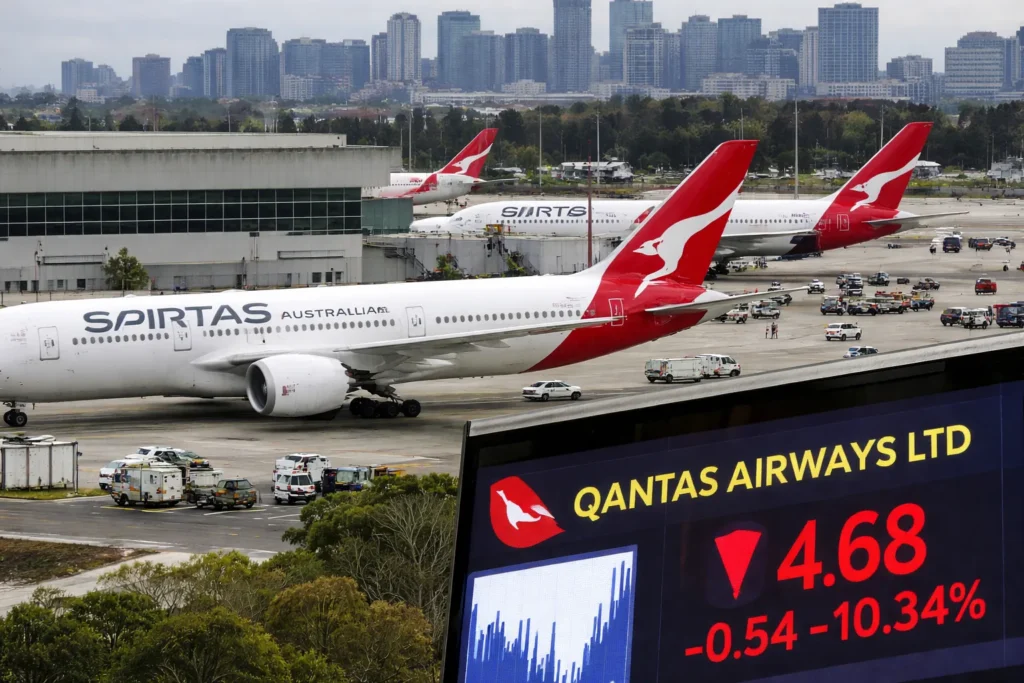 Qantas aircraft parked at Sydney Kingsford Smith Airport with city skyline in background